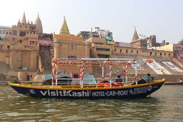 Decorated boat beside the illuminated Varanasi ghats